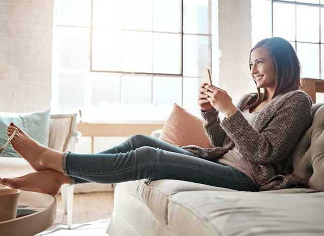 ソファーでスマホをする女性
